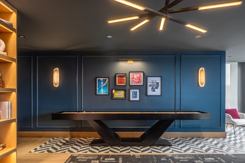 A room with a blue wall and a black and white patterned rug.