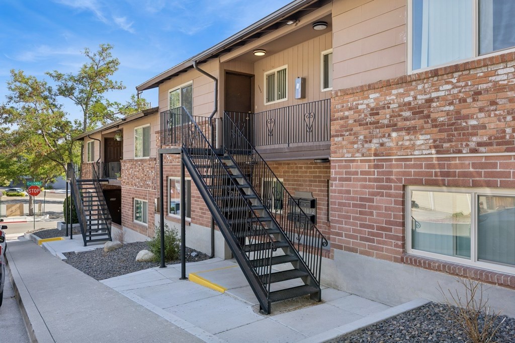 A building with a brick wall and a black metal staircase.