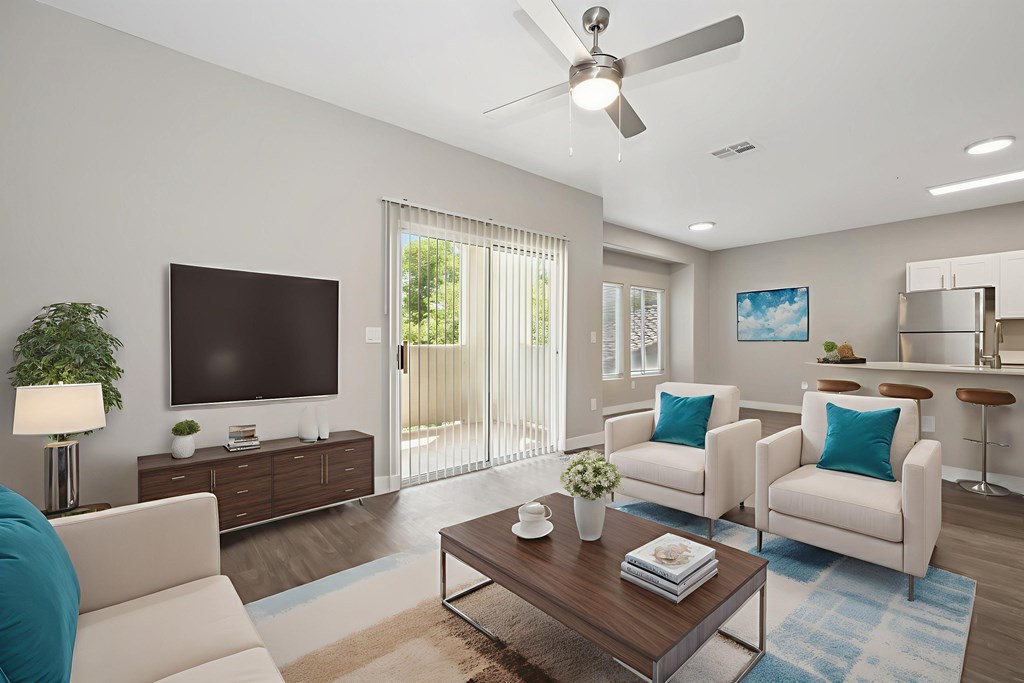 A living room with a white couch, a wooden coffee table, and a flat screen TV.