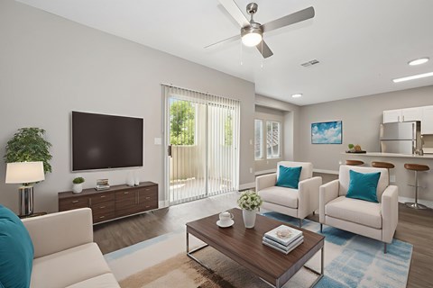 A living room with a white couch, a wooden coffee table, and a flat screen TV.