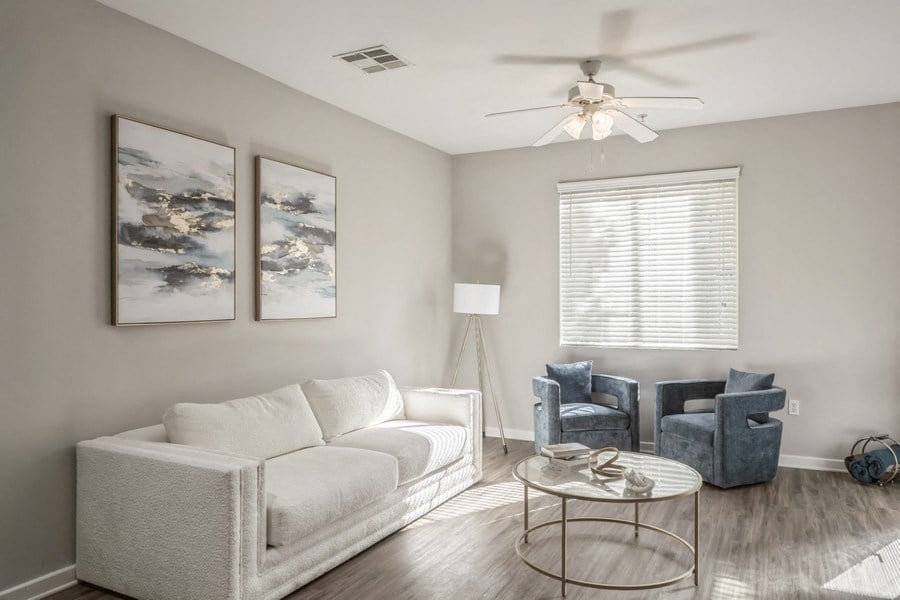a living room with a white couch and a ceiling fan