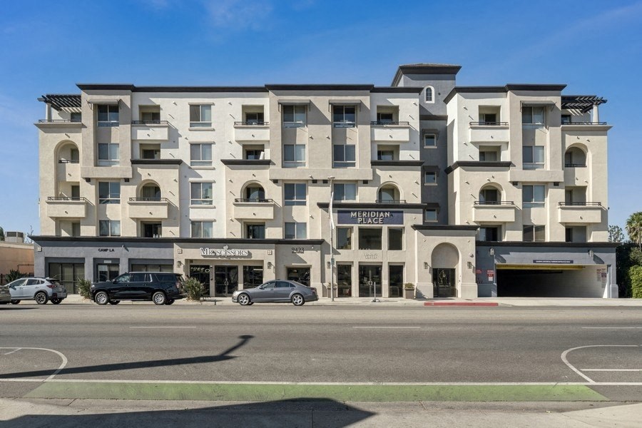 a street view of a building with cars parked in front of it