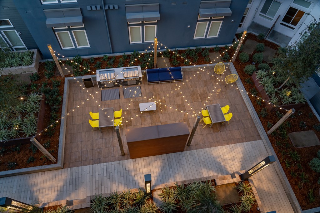 an aerial view of a patio with chairs and lights