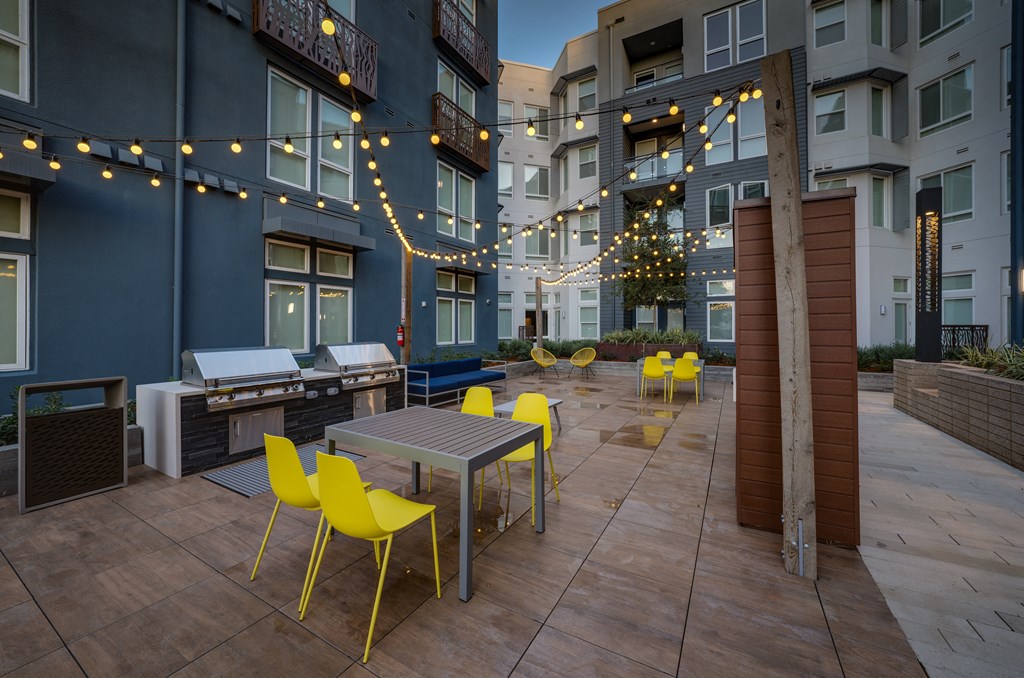 an outdoor patio with tables and chairs and string lights