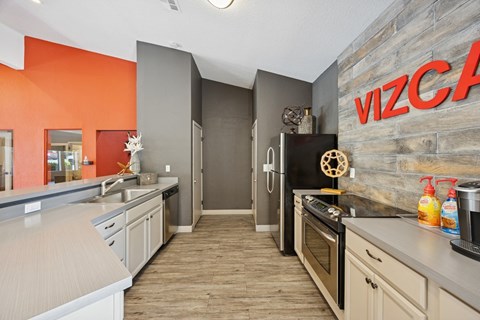 A kitchen with a refrigerator and a microwave.