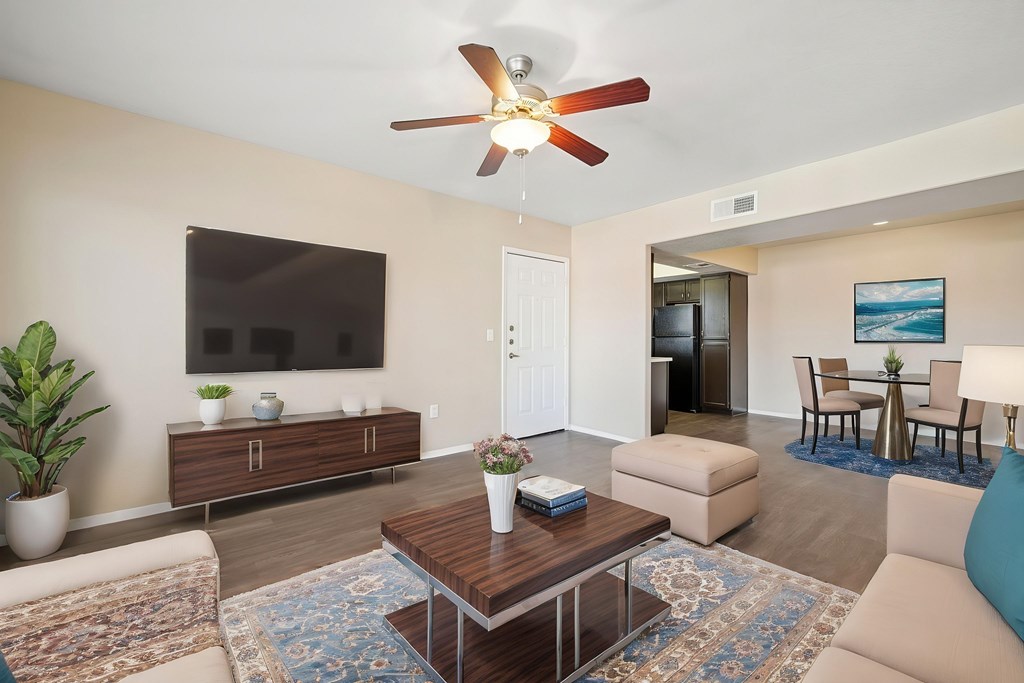 A living room with a brown coffee table and a ceiling fan.