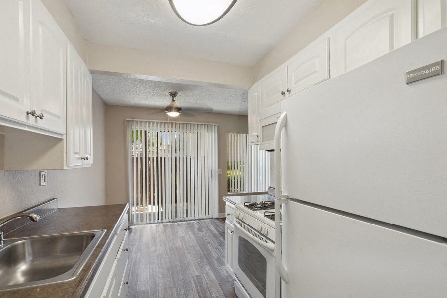 the kitchen of an apartment with white cabinets and stainless steel appliances