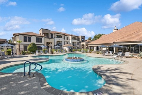 a swimming pool with a fountain in front of a building