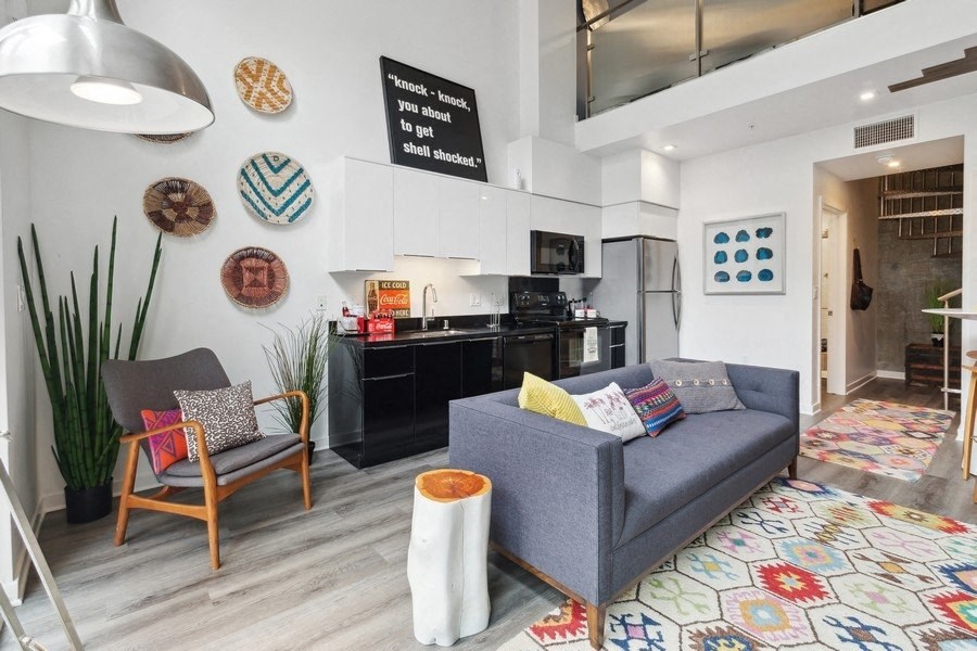 a living area with a couch chair and a kitchen in the background