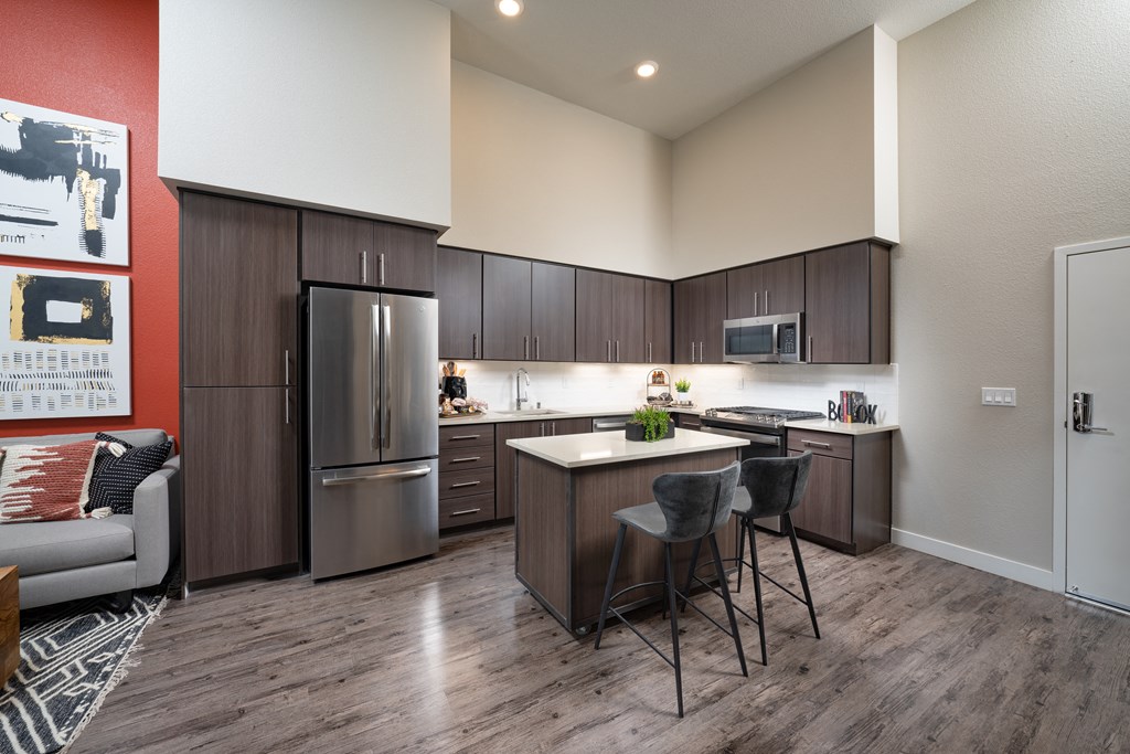 a kitchen with stainless steel appliances and a island with three stools