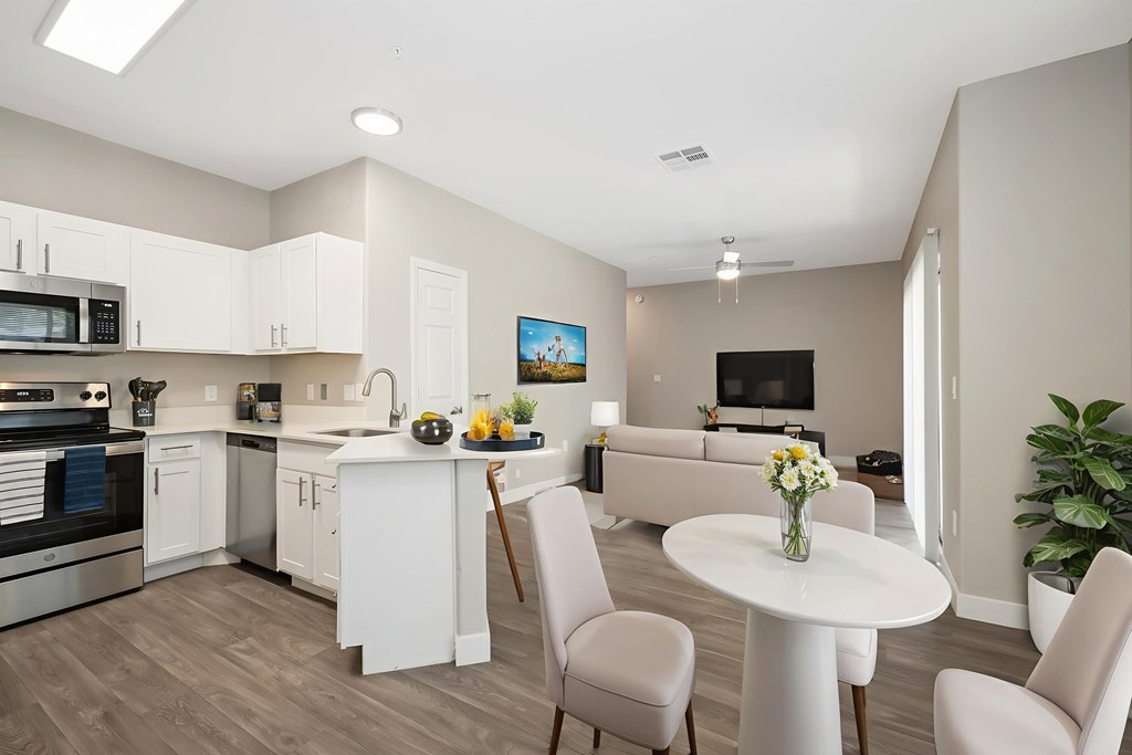 A modern kitchen with a dining table and chairs.