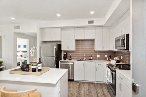 a kitchen with white cabinets and stainless steel appliances