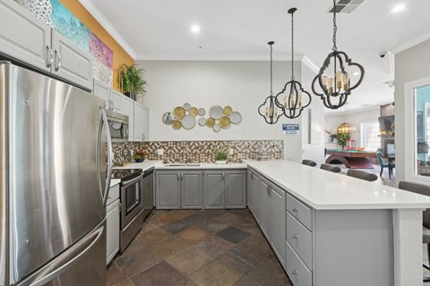 the kitchen has stainless steel appliances and a large white counter top
