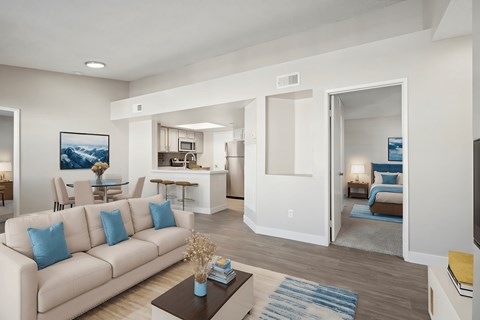 A living room with a white couch and a painting on the wall.