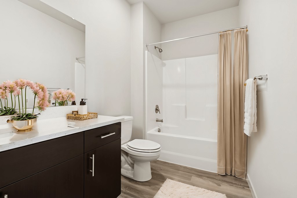 A white bathroom with a toilet, sink, and shower.