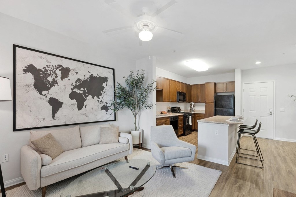 a living room with a couch and a chair and a kitchen