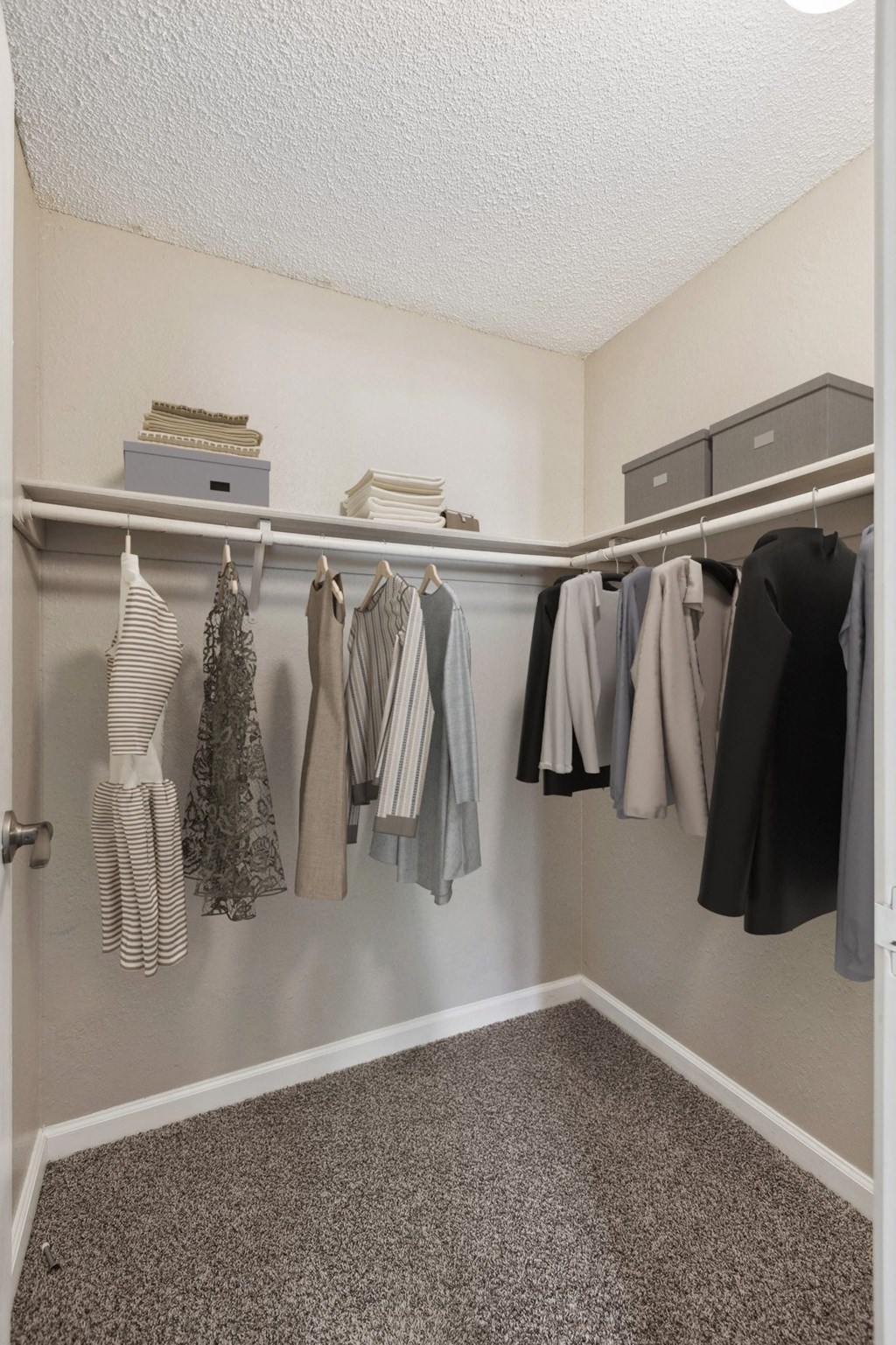 an image of a closet with clothes hanging on a rack