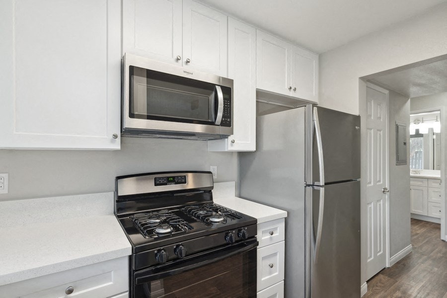 a kitchen with stainless steel appliances and white cabinets