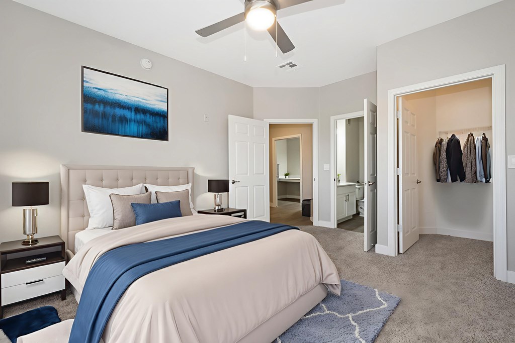 A bedroom with a large bed and a ceiling fan.