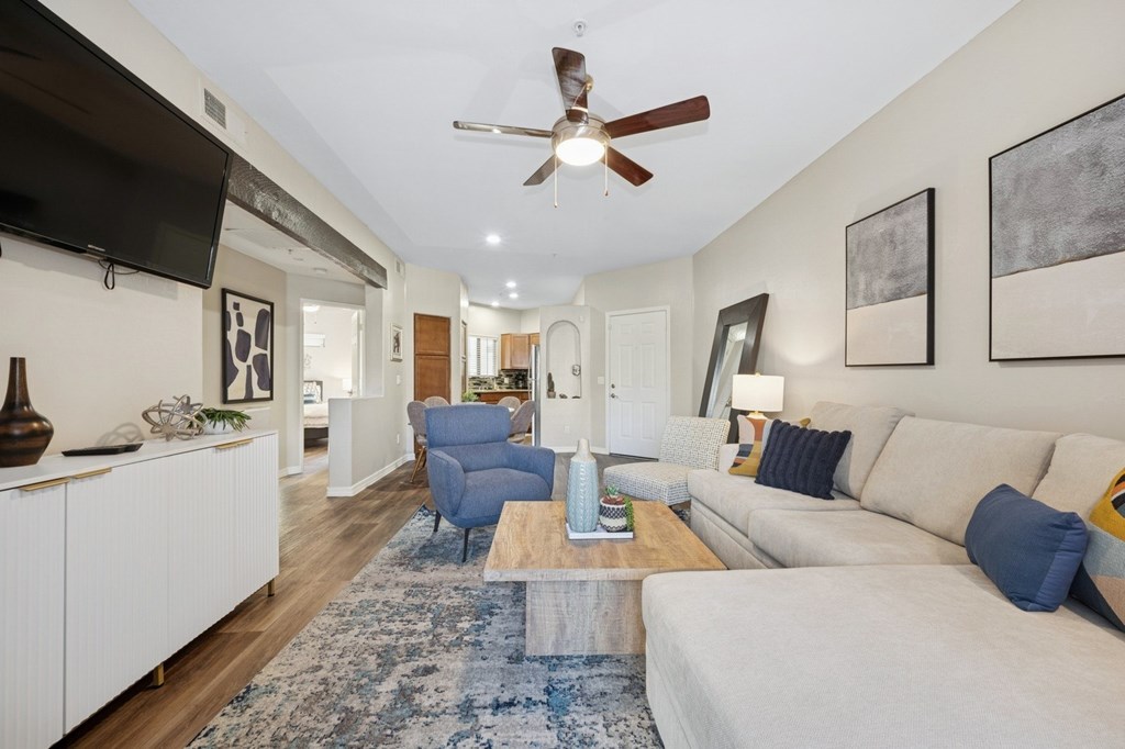 A living room with a white couch and a blue rug.