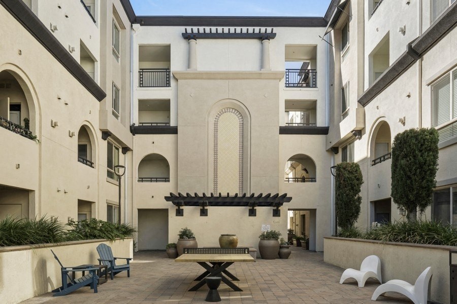 a courtyard with a table and chairs in an apartment building
