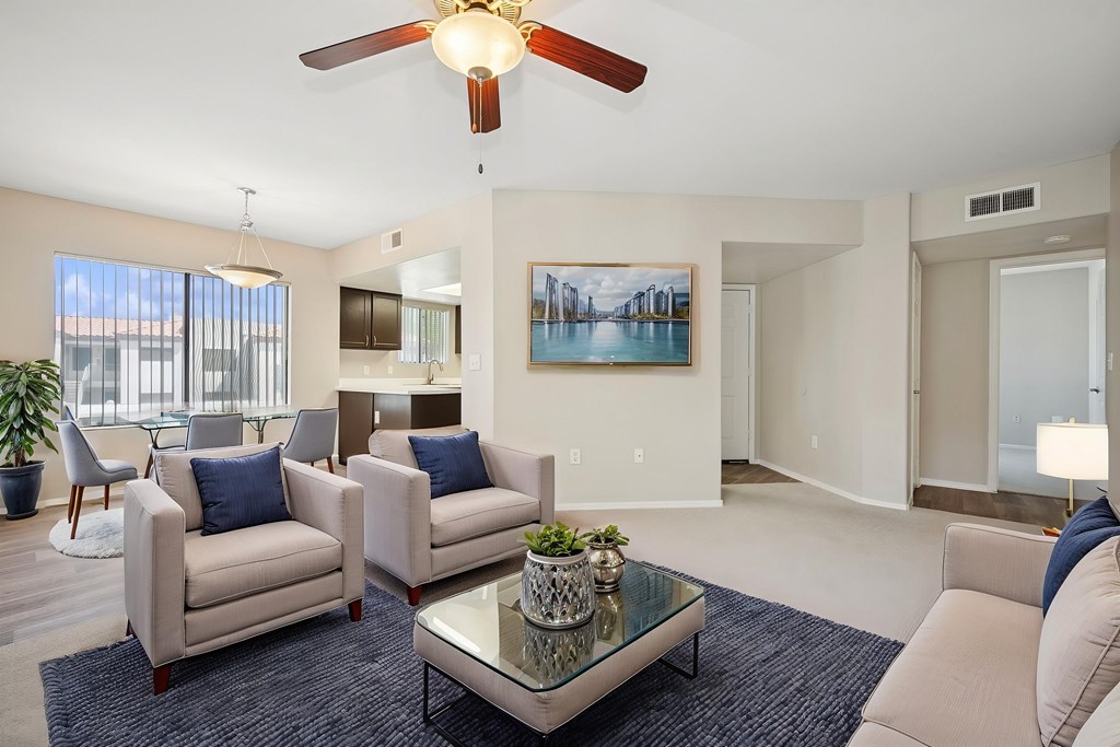 A living room with a ceiling fan, two couches, and a coffee table.