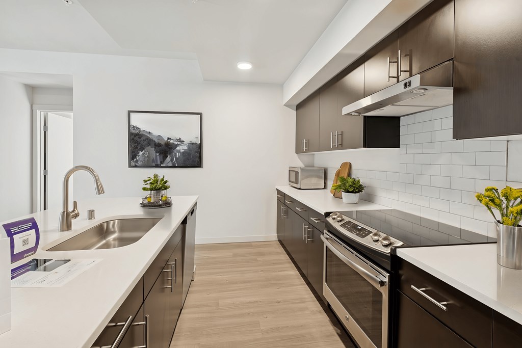A modern kitchen with a stainless steel oven and a white countertop.
