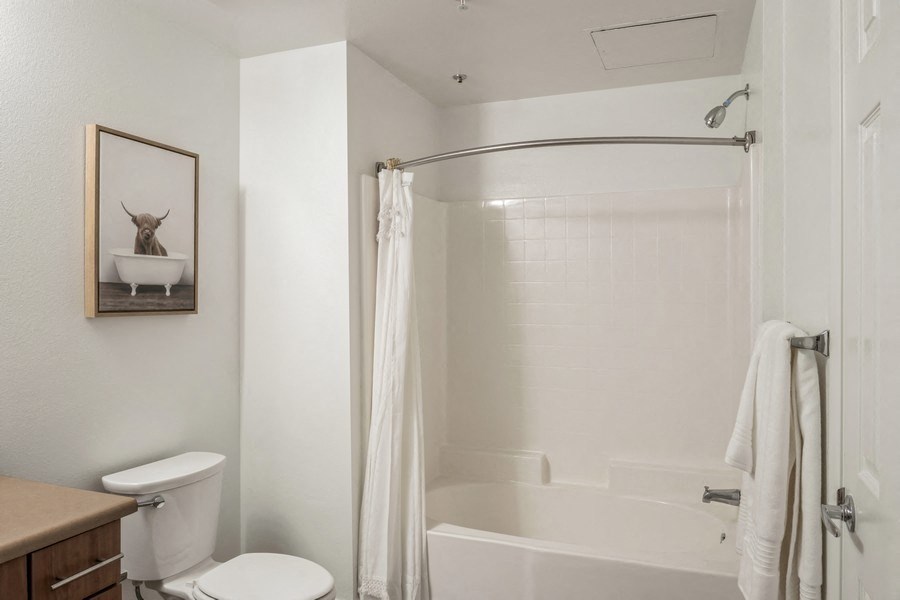 a bathroom with a shower and a toilet and a sink