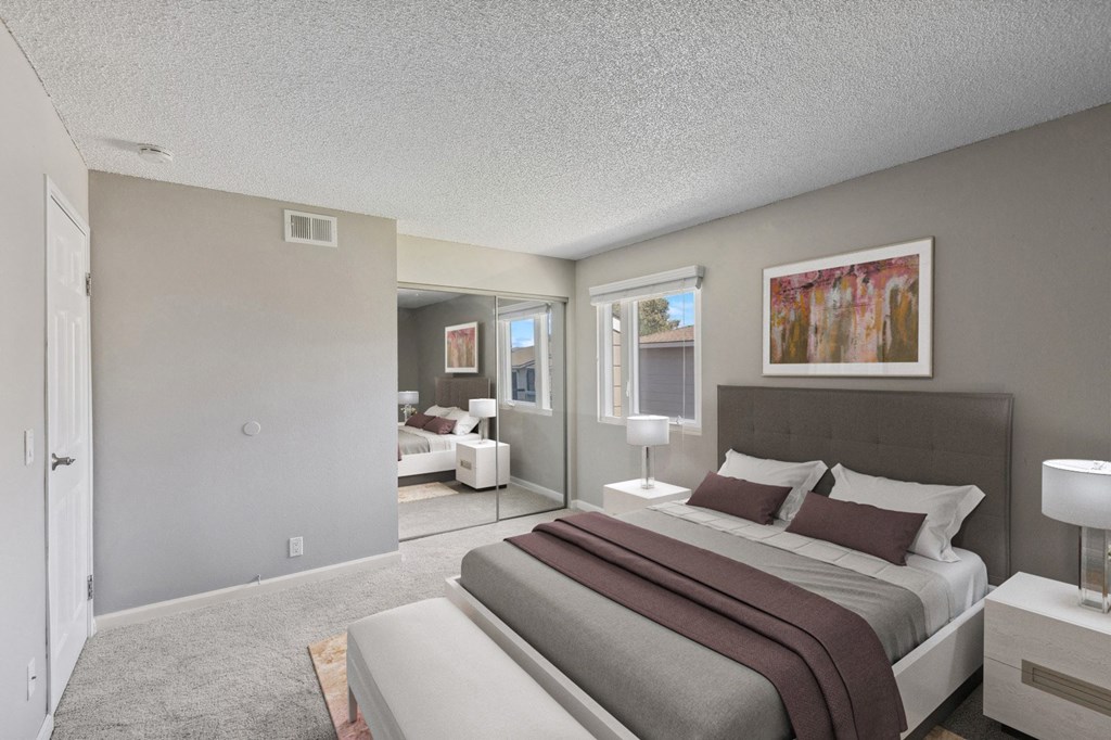 a bedroom with a bed and a couch and a window