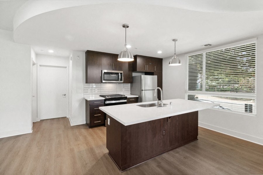a kitchen with a white counter top and a window