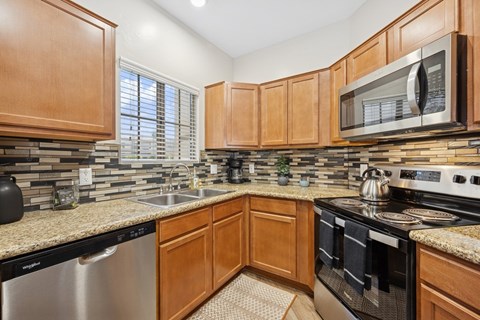 A kitchen with wooden cabinets and a granite countertop.