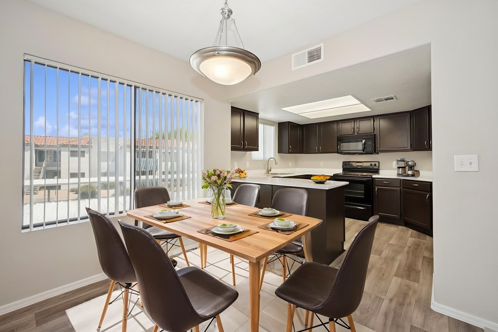 A modern dining room with a wooden table and chairs.
