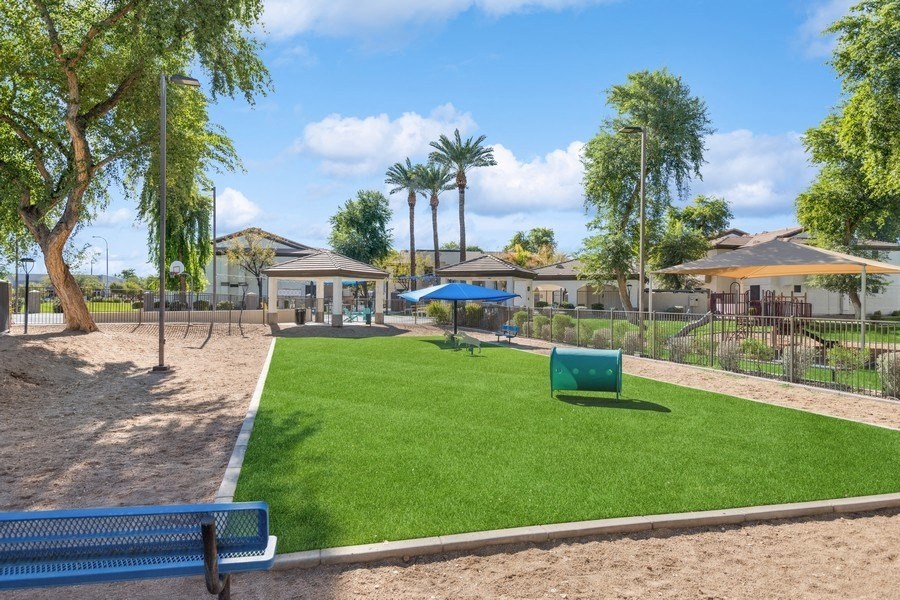 a park with a playground and picnic tables and trees