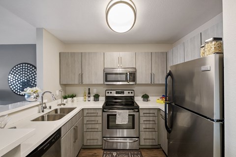 a kitchen with stainless steel appliances and a sink and a refrigerator