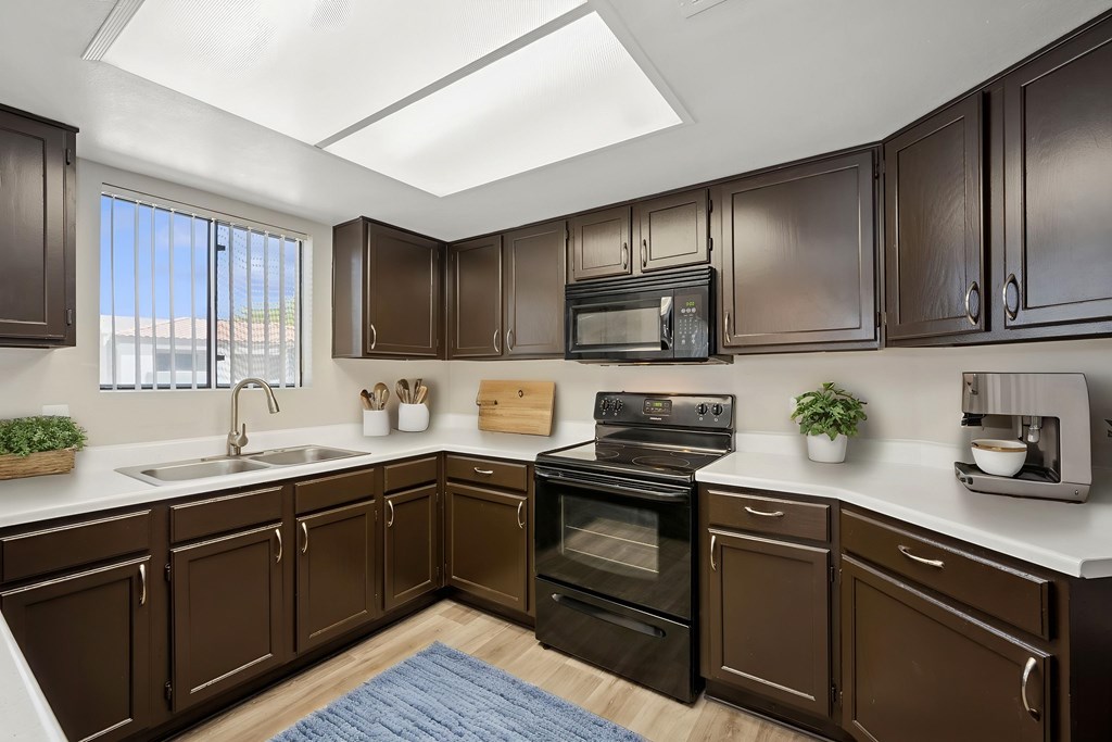 A kitchen with brown cabinets and a black stove top oven.