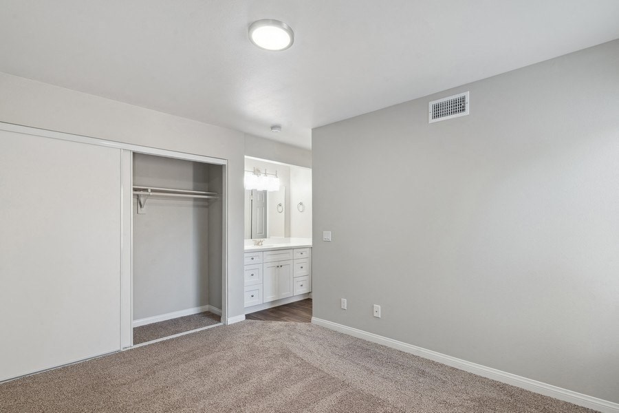 an empty bedroom with a closet and a bathroom