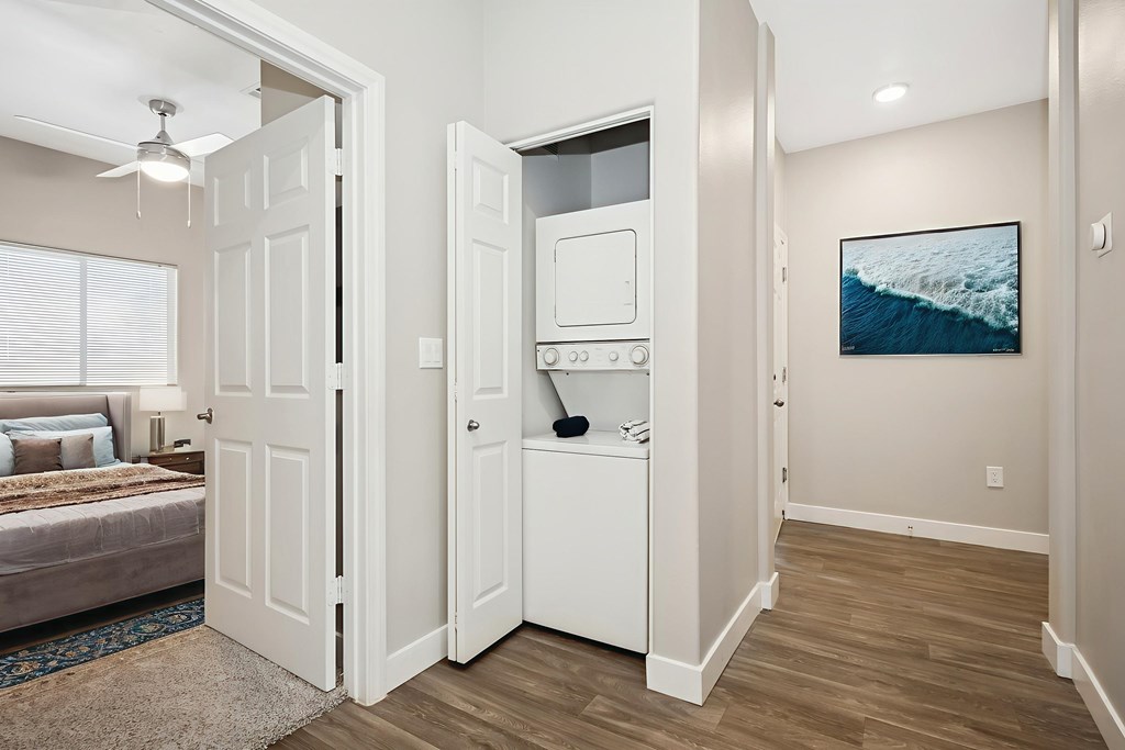 A modern kitchen with white appliances and a wooden floor.