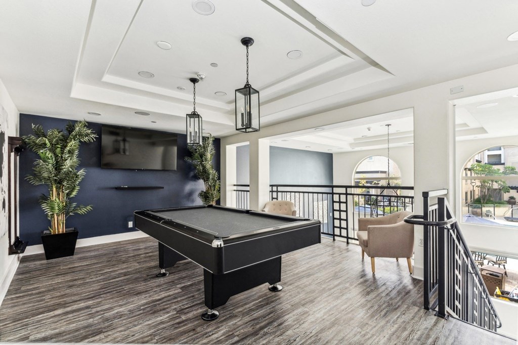 a game room with a pool table and a tv