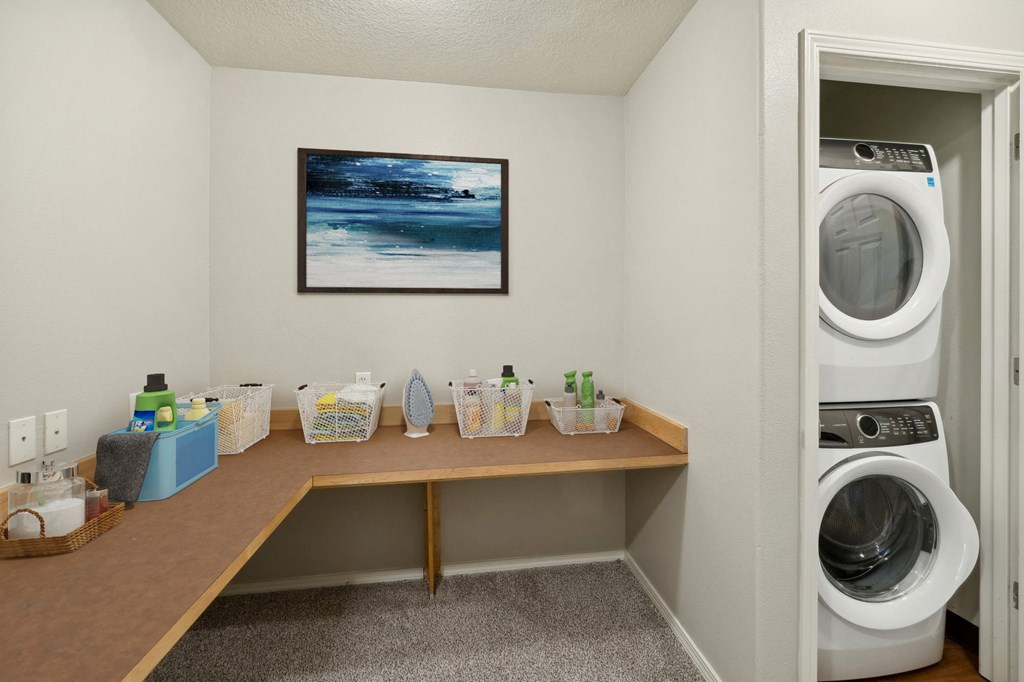 a washer and dryer in a laundry room with a desk and a washing