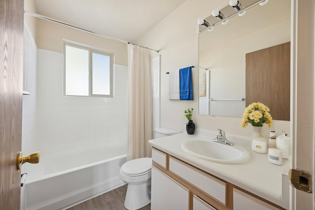 A white bathroom with a toilet, sink, and bathtub.