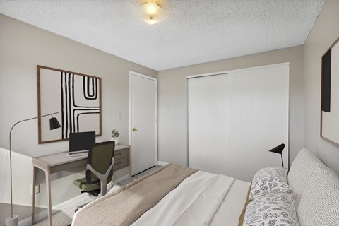 a bedroom with a bed and a desk with a computer
