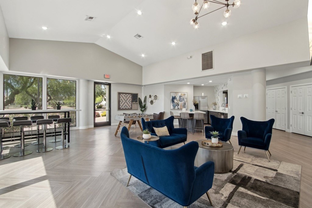 A spacious living room with blue chairs and a dining table.