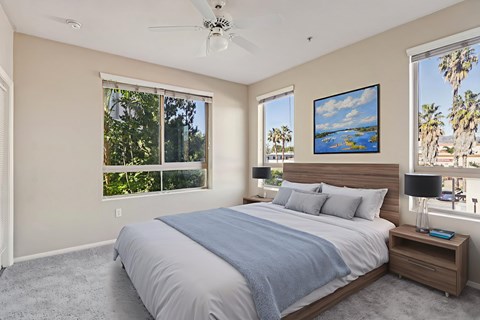 A bedroom with a large bed and a ceiling fan.