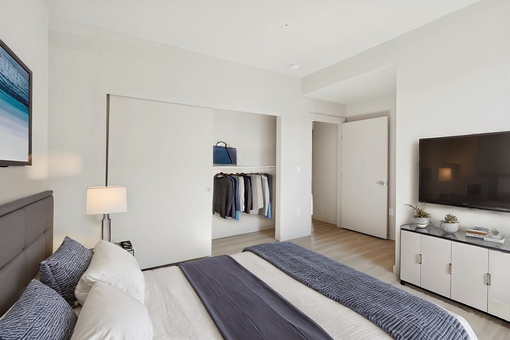 A bedroom with a large bed and a television in the corner.