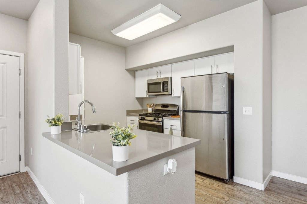 a kitchen with stainless steel appliances and a large counter top