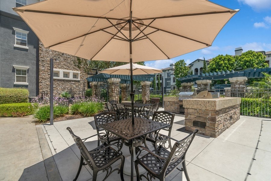 a patio with a table and chairs and a fire pit