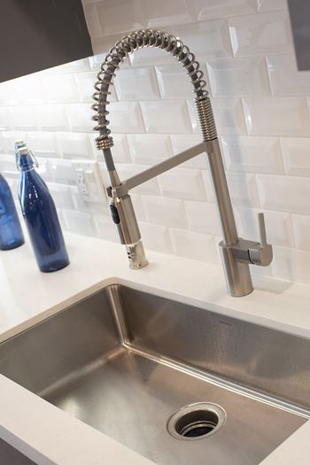 a stainless steel sink with a faucet in a kitchen