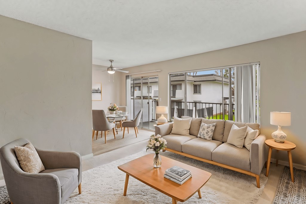 A living room with a grey couch, a wooden coffee table, and a grey armchair.