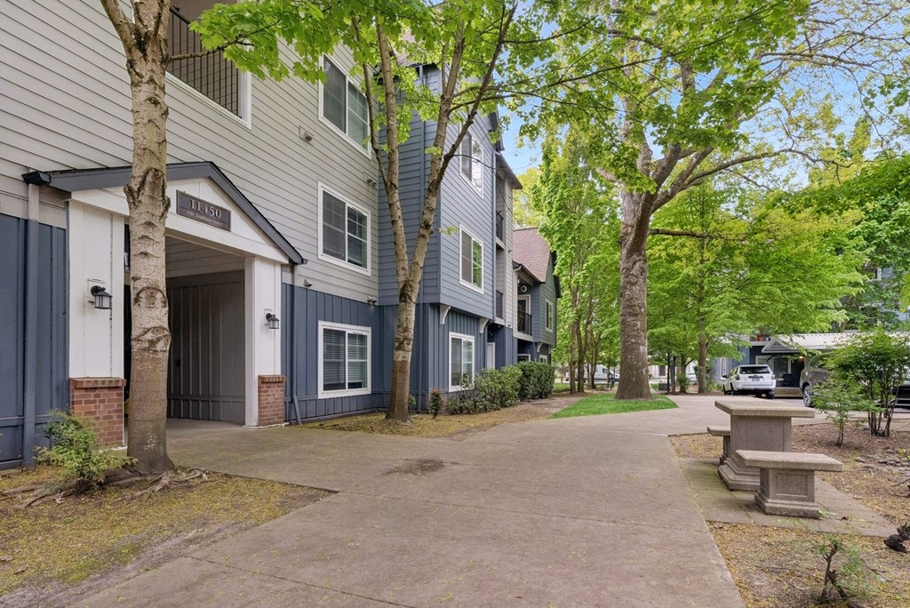 A tree-lined walkway leads to a building with a sign that reads "RESIDENTS".