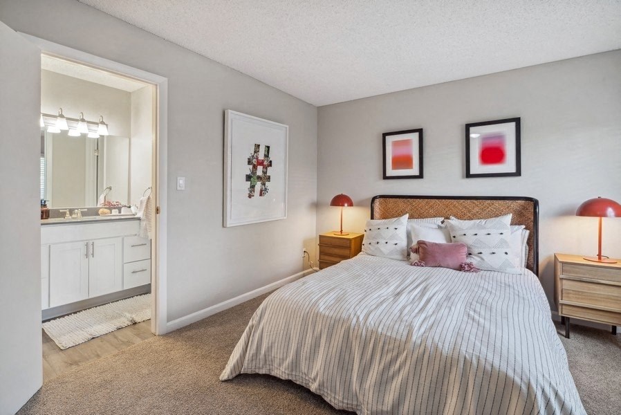 a bedroom with a bed and a bathroom with a sink